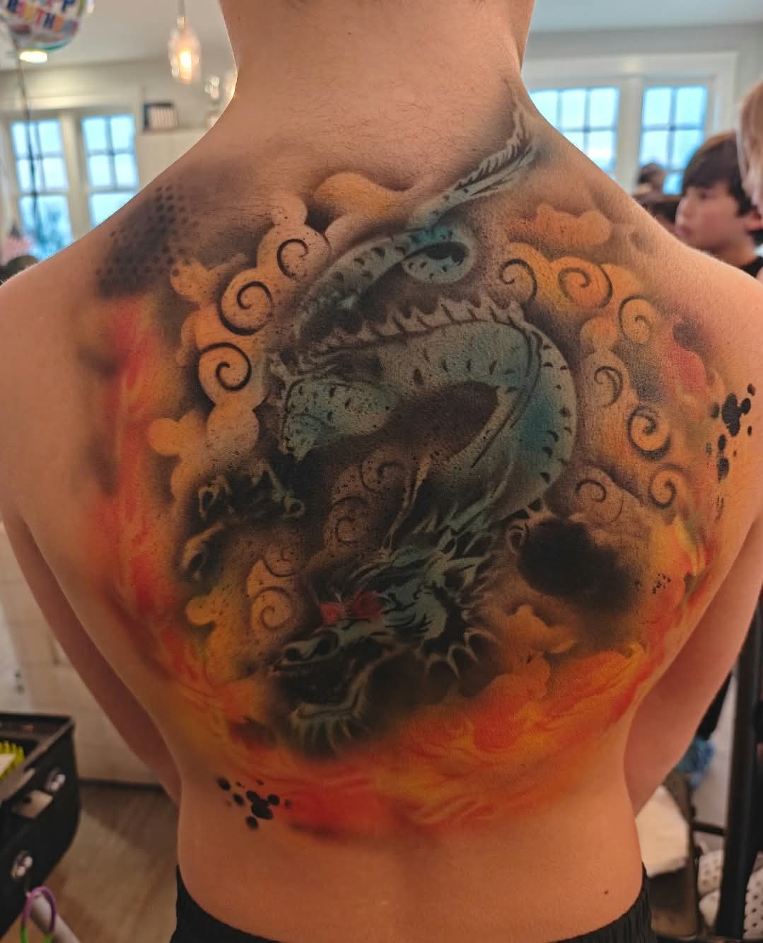 A full-back airbrushed dragon in flames, sprayed at an event