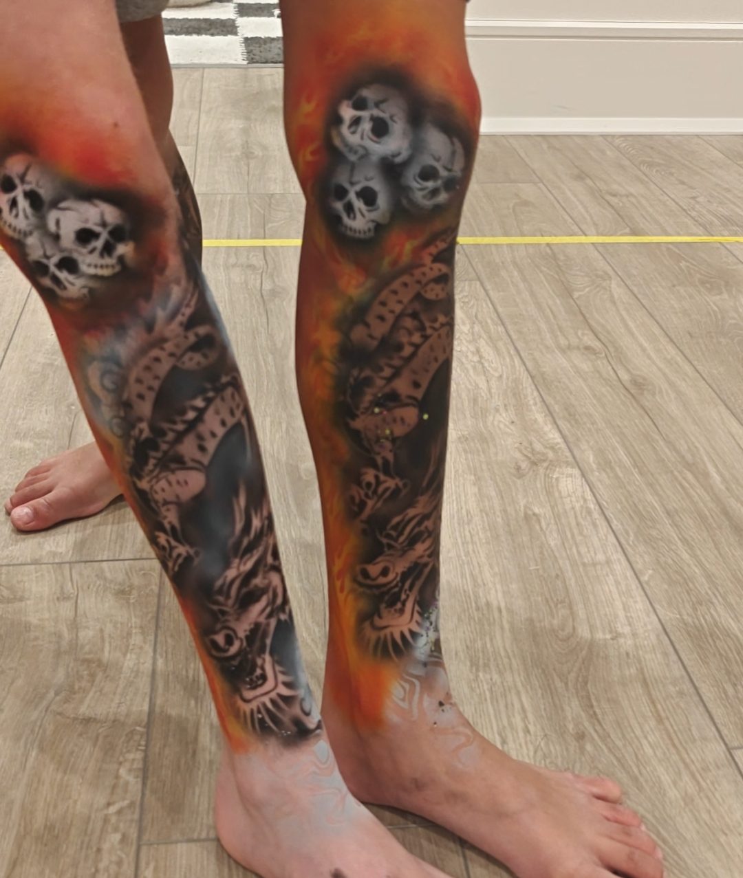 Matching airbrushed dragon and skull sleeves down both calves