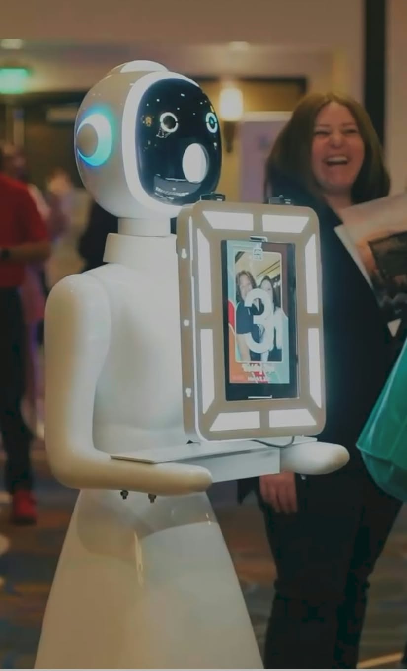 The roaming robot photo booth handing a print to a laughing guest