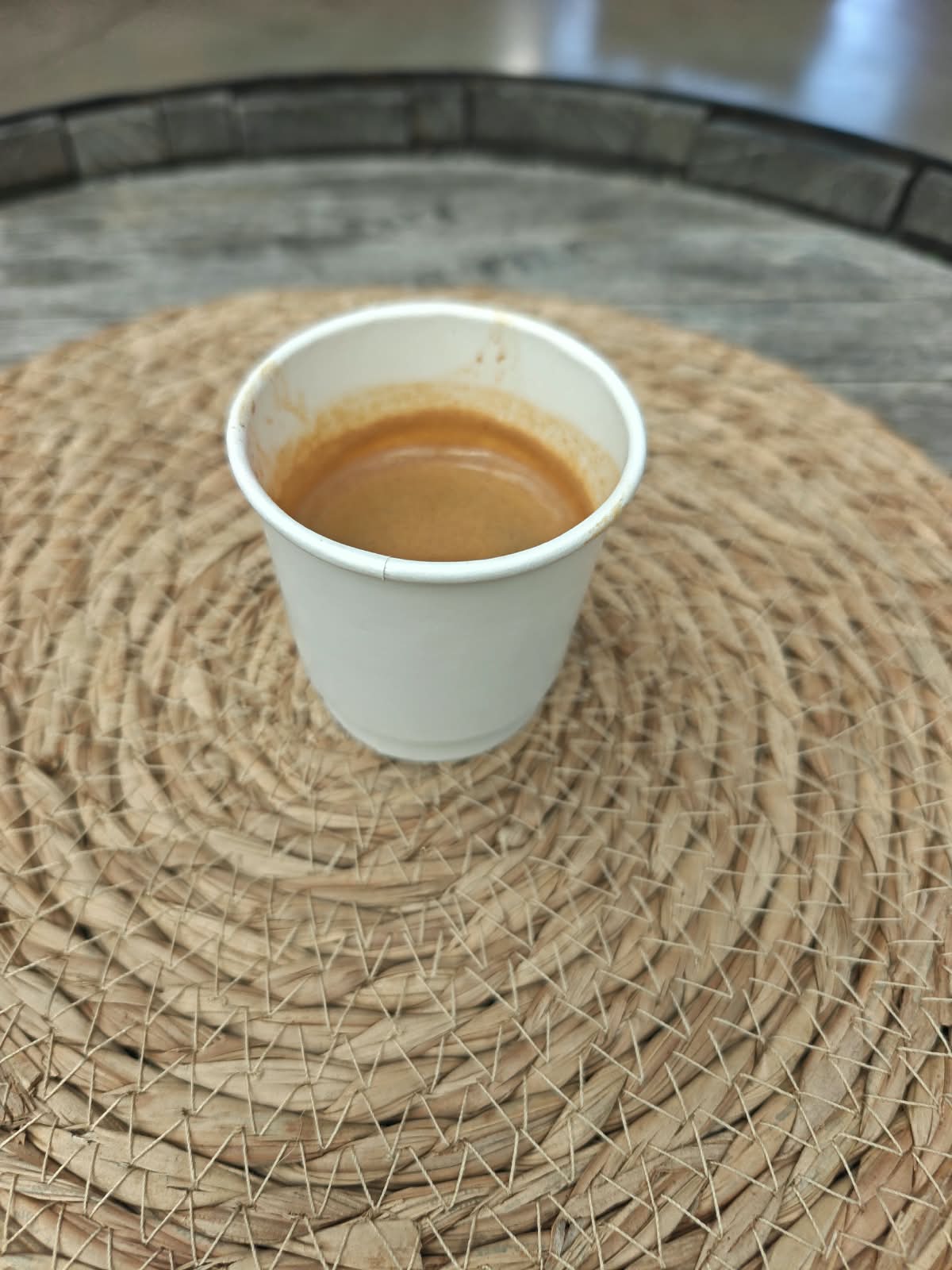 A fresh shot of espresso in a white cup with visible crema